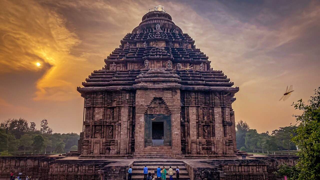 A beautiful sunset over a temple, with vibrant orange and pink hues.