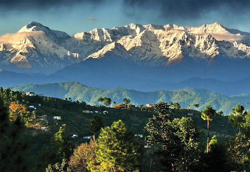 Village house with backdrop of Snow covered Himalayan mountains