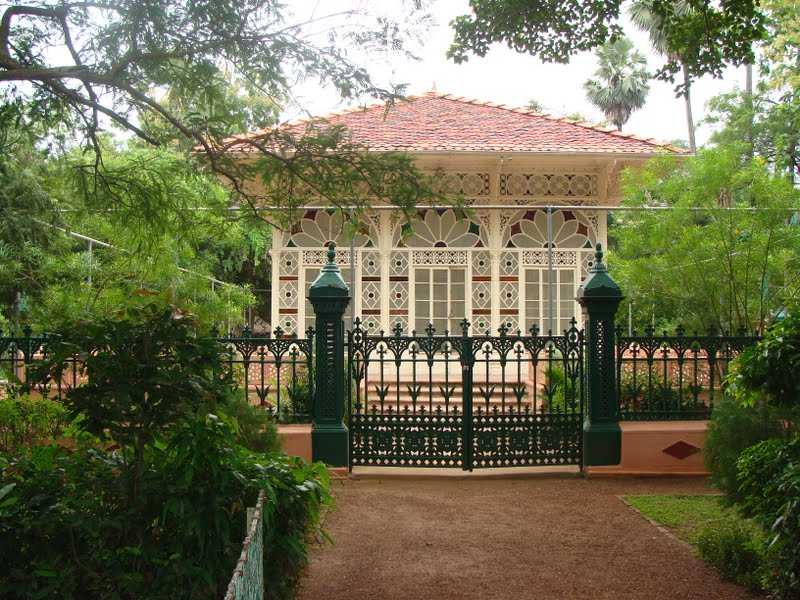 A peaceful garden featuring a gazebo and a gate.