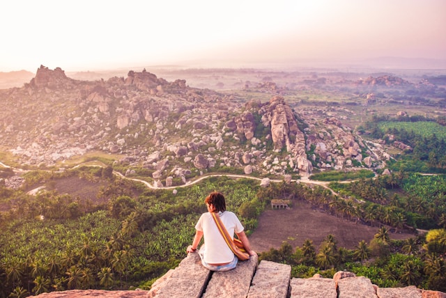 A beautiful sunset over the Hampi Ruins with vibrant orange and pink hues reflecting on the mountains.