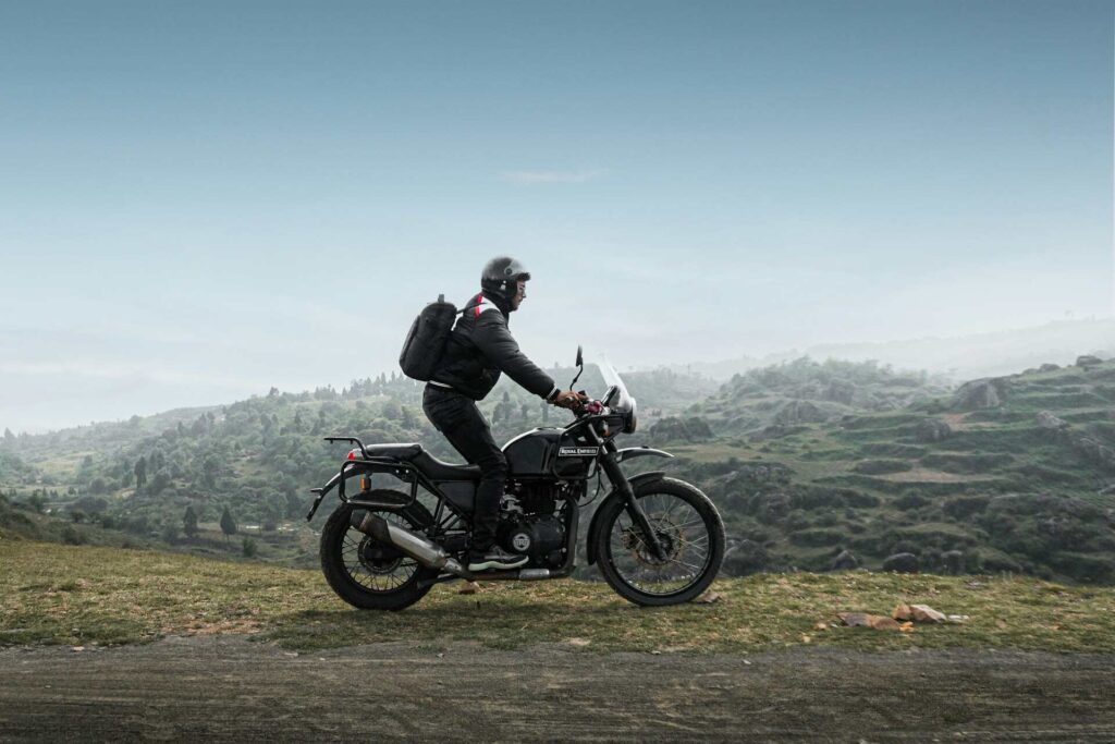 A person standing on his bike on a dirt road