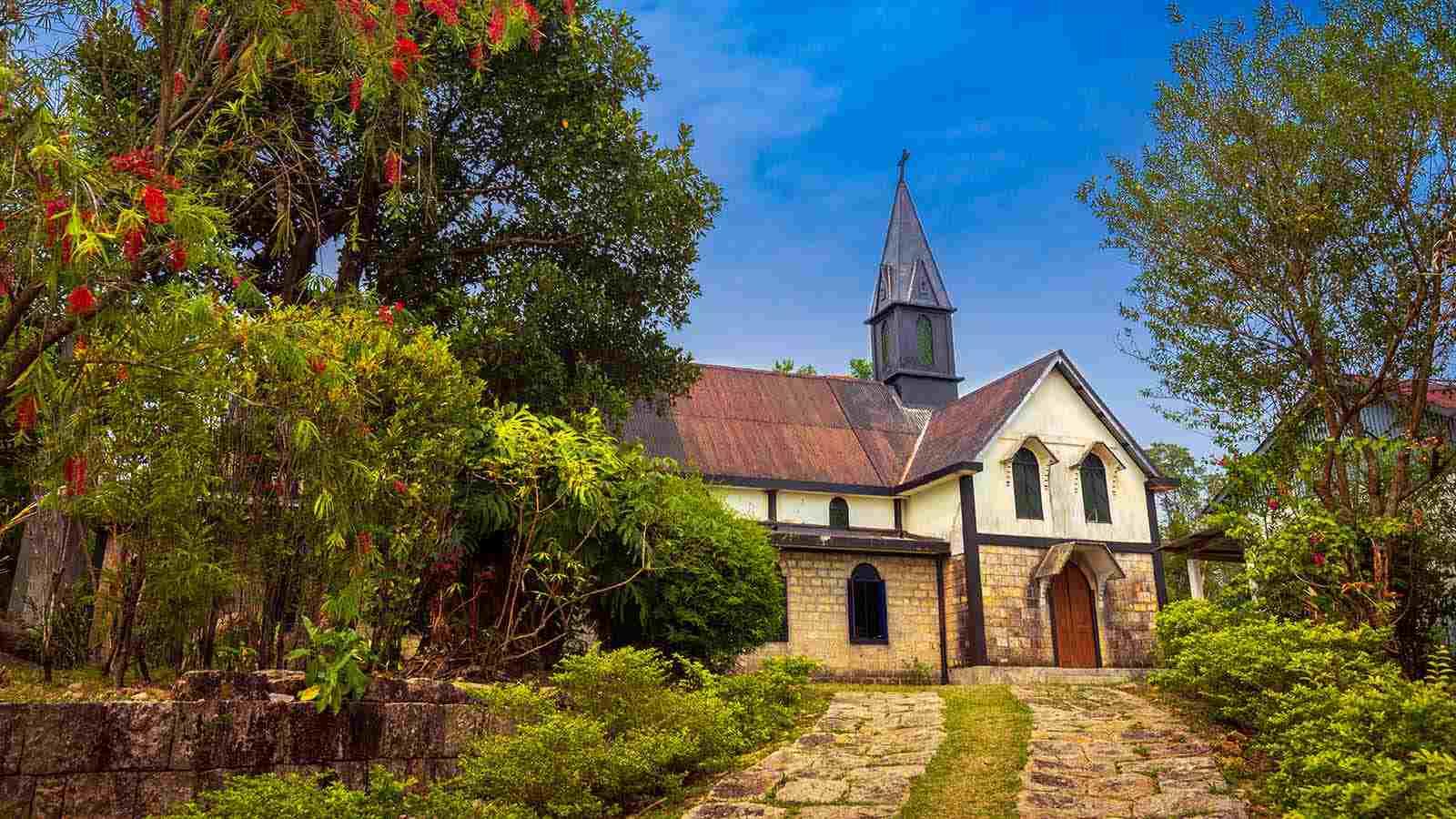 A picturesque church stands amidst a vibrant green park, creating a serene and tranquil scene.