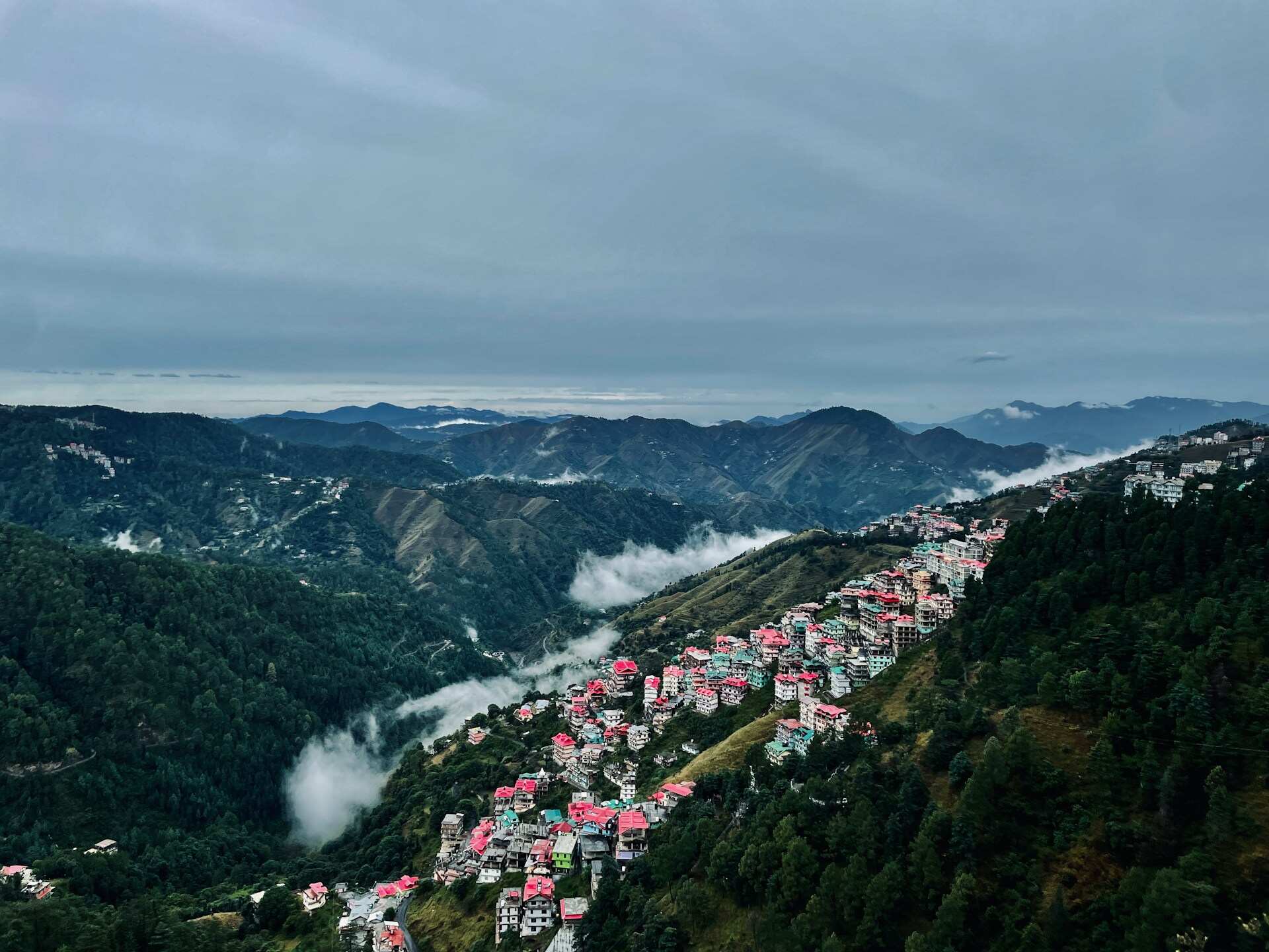 A picturesque town nestled on a hillside with majestic mountains in the background