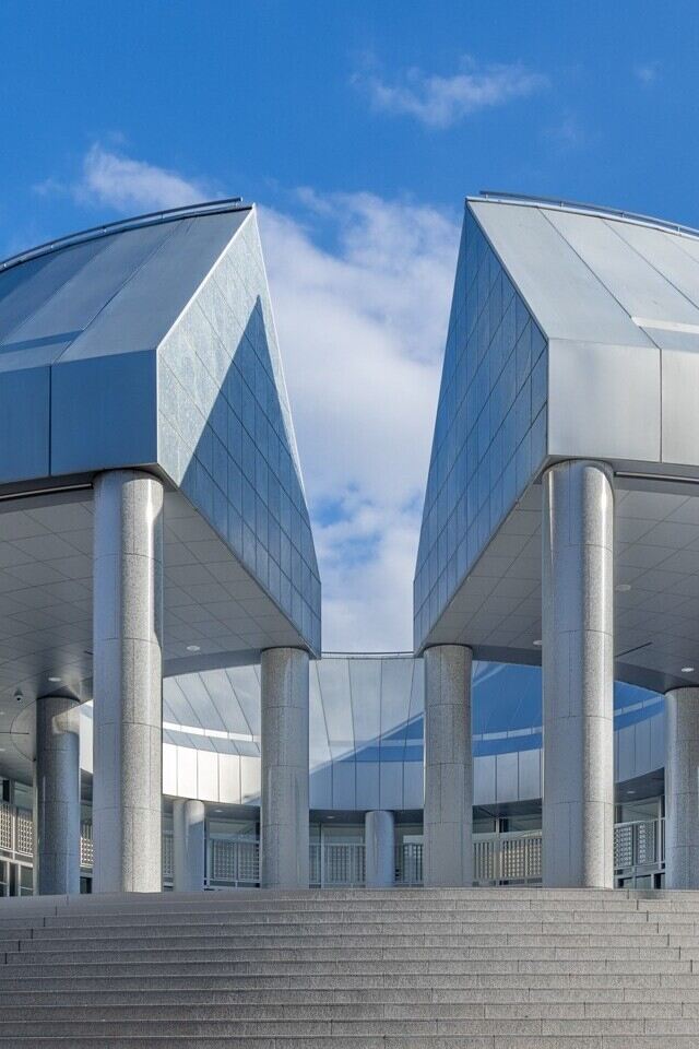 Modern building entrance with metal door, showcasing contemporary architecture.