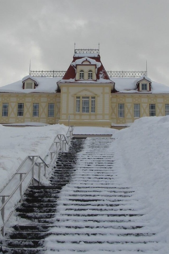 A grand building with a staircase leading to its entrance, exuding an air of elegance and grandeur.