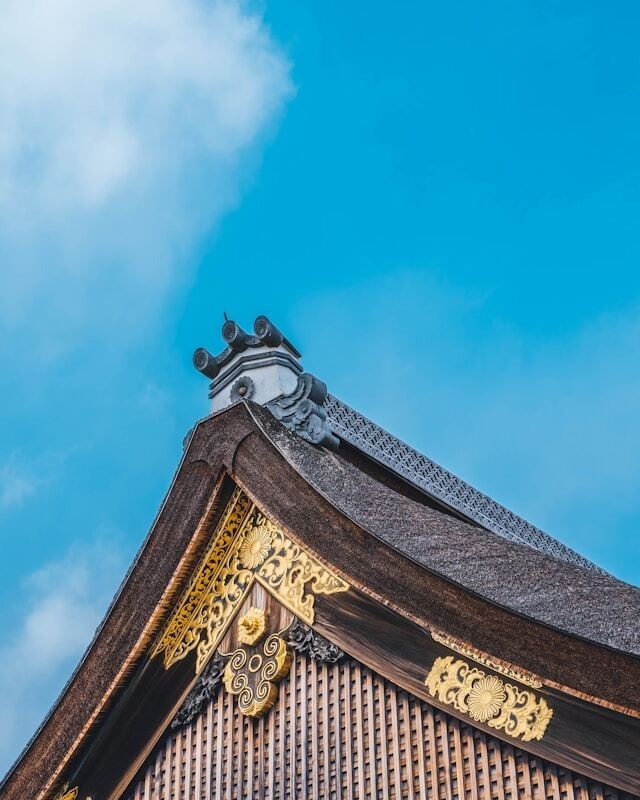 Japanese temple roof against blue sky.