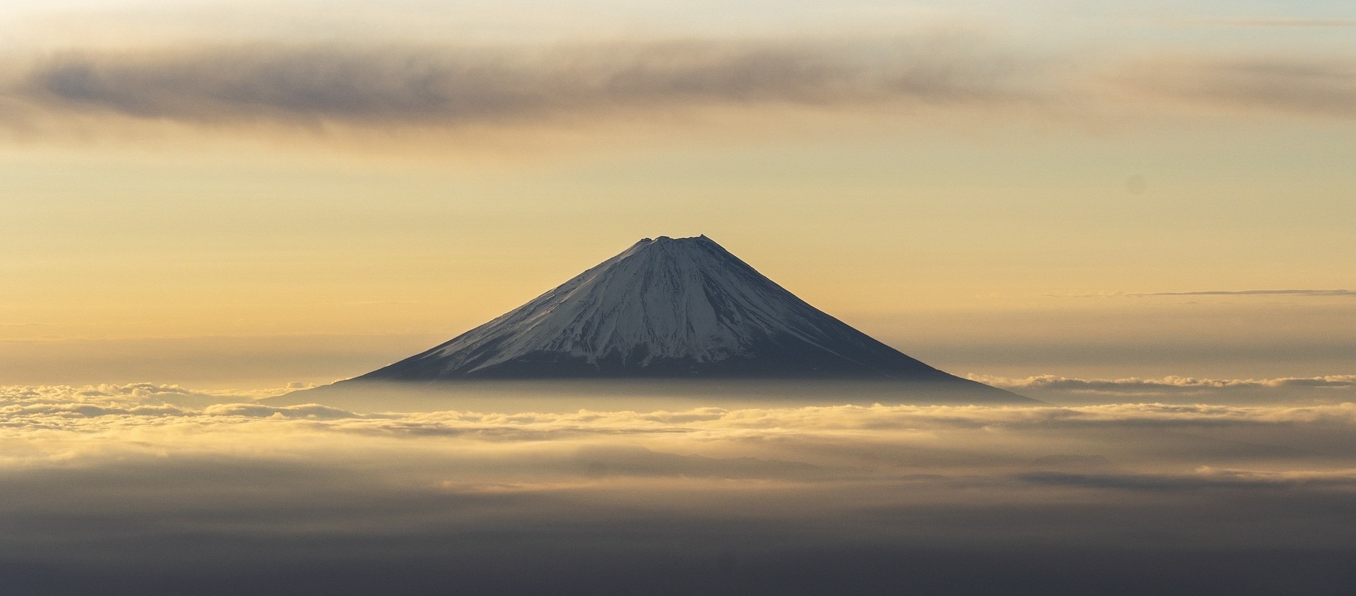 Mount Fuji majestically rising above the clouds, showcasing its iconic cone shape and serene beauty.