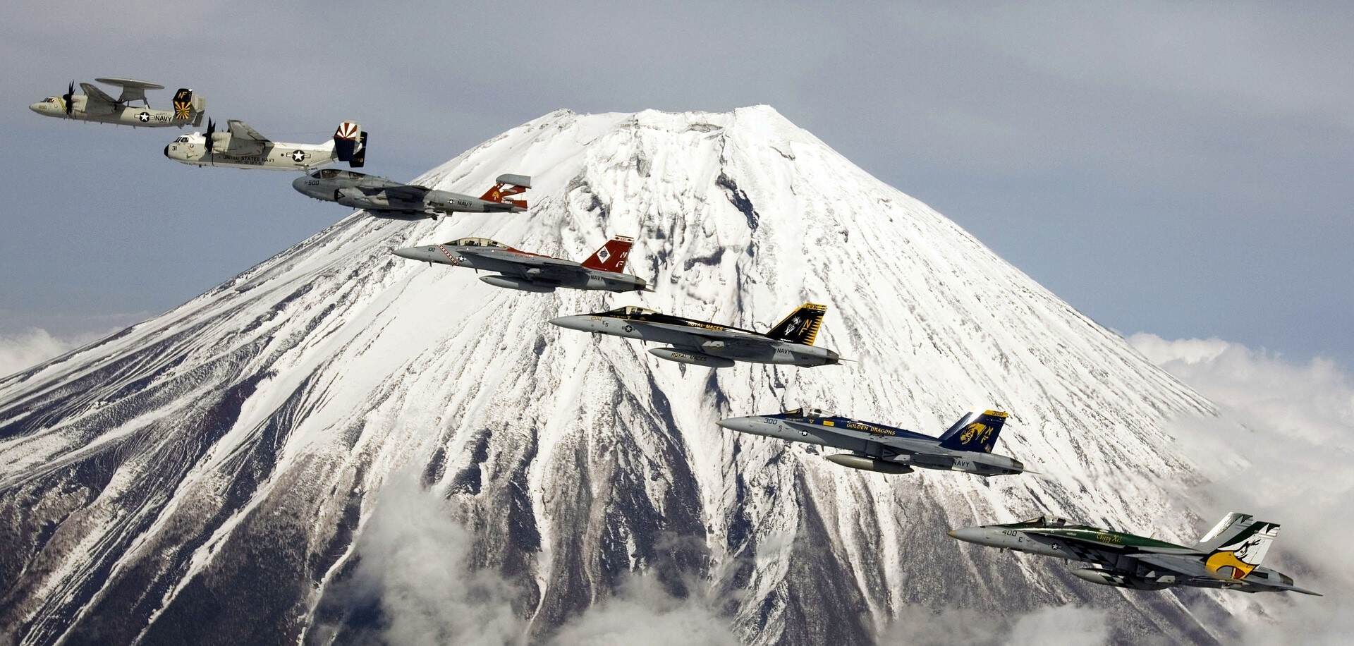 A squadron of military jets soaring above majestic Mt. Fuji, showcasing the power and precision of aerial maneuvers.