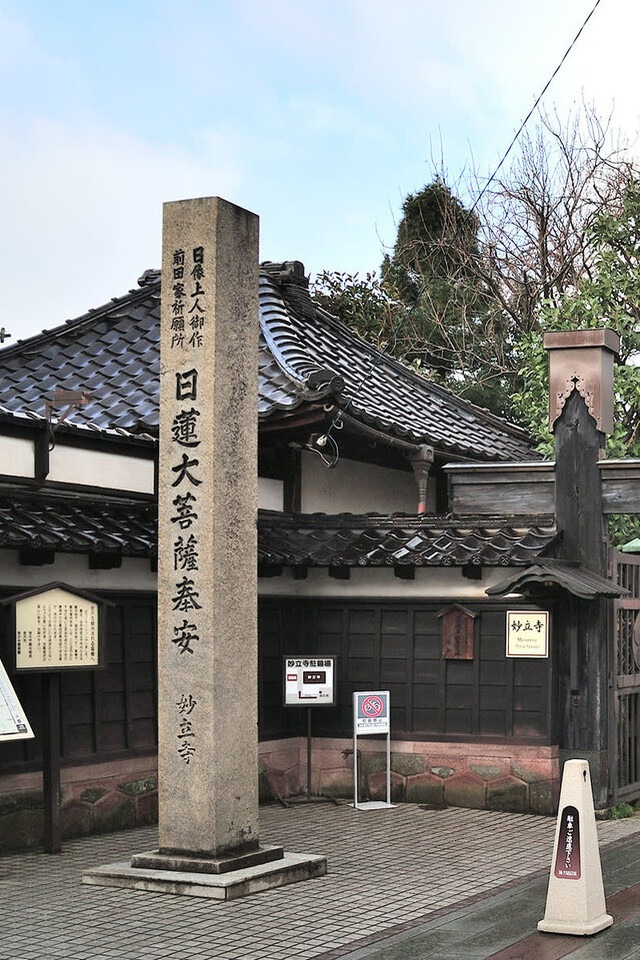 An old Japanese building with a sign reading "Welcome" in front.