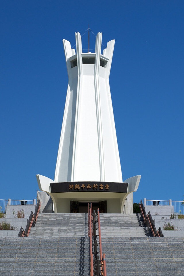 A tall white tower standing against a clear blue sky.