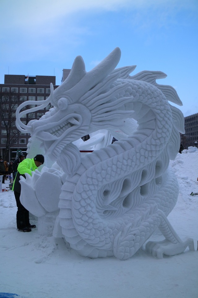 A man sculpting a dragon out of snow during Sapporo Snow Festival