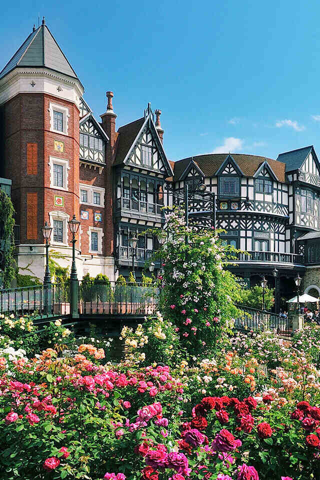 A sprawling building with numerous windows and a bridge in front of it.