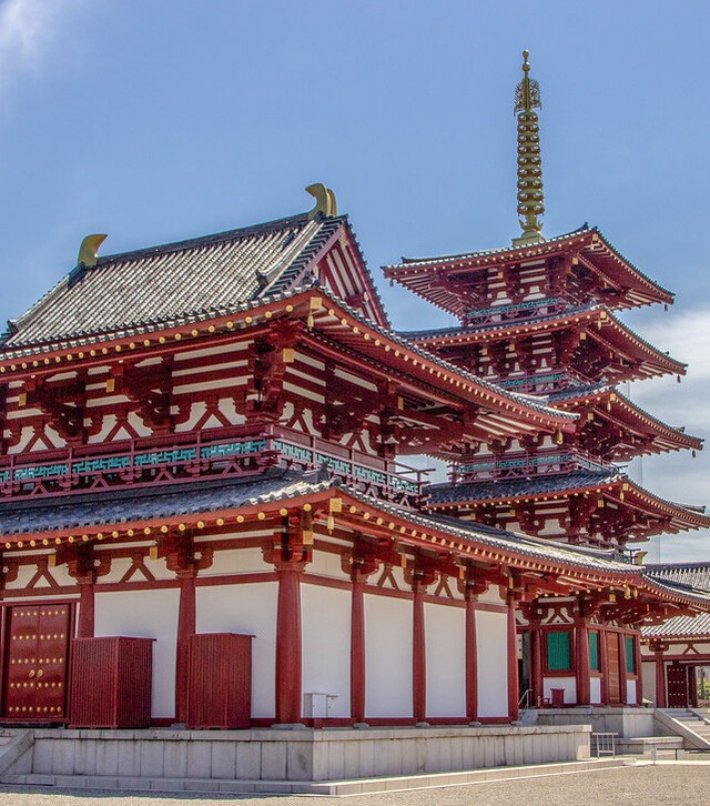 A large building with red and white trim, standing tall against a clear blue sky.