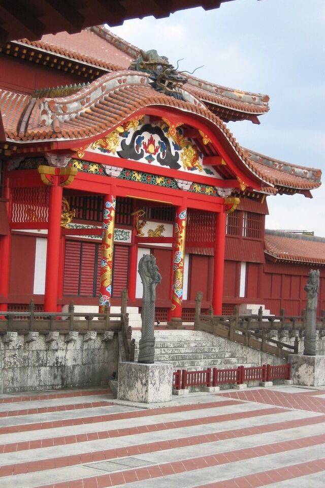 Red building with a large red roof against a clear blue sky.